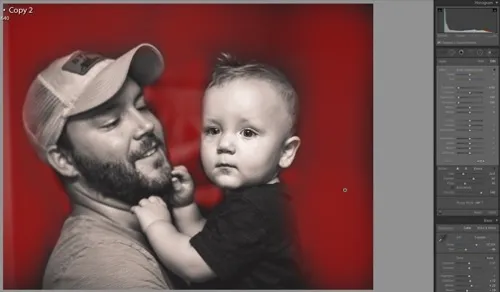 Lightroom brush overlay in red showing the darkened background around father and baby